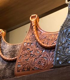 three leather purses sitting on top of a wooden shelf