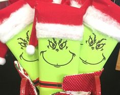 three green christmas stockings with faces drawn on them