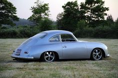 an old silver car parked in the grass