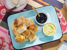 a blue tray topped with food next to a bowl of dip