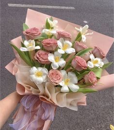 a bouquet of pink roses and white flowers