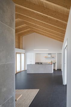 an empty kitchen and living room are shown in this house with wood ceilinging on the walls