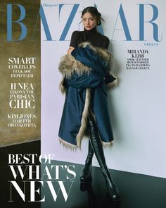 a woman standing on top of a magazine cover wearing a blue coat and black boots