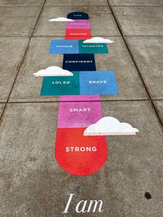 the sidewalk has many different colored signs on it that read, i am loved, brave, smart and strong