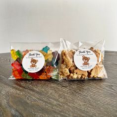 two bags filled with gummy bears on top of a wooden table