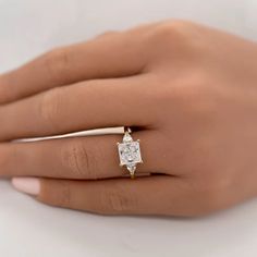 a woman's hand with a diamond ring on it