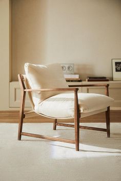 a white chair sitting on top of a hard wood floor next to a wooden table