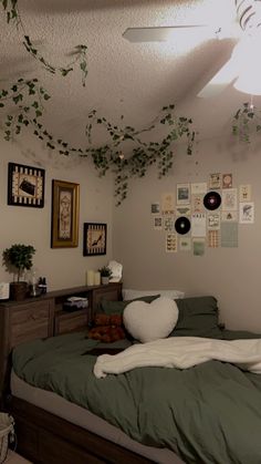 a bed room with a neatly made bed and lots of pictures on the wall above it