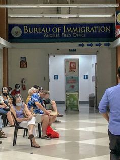 people are sitting in chairs at the bureau of immigration