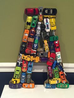 a letter made out of toy cars sitting on top of a table