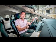 a man sitting in the driver's seat of a car holding a steering wheel