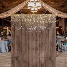 a wooden wall with lights hanging from it's sides and the words, amanda & christian on it