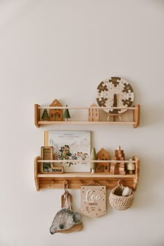 two wooden shelves with toys on them against a white wall