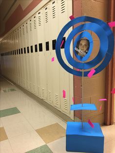 a blue sculpture with a child's face on it in front of lockers