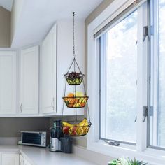 a kitchen filled with lots of white cabinets and counter top space next to a window