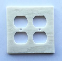 a white marble outlet cover with three holes