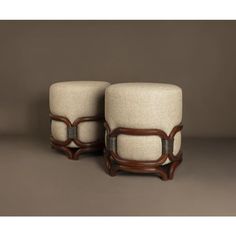 two wooden and upholstered stools sitting side by side on a brown background