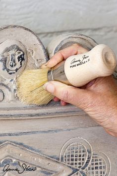 a person is using a brush to paint a piece of art