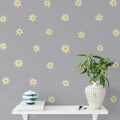 a potted plant sitting on top of a white table next to a gray wall