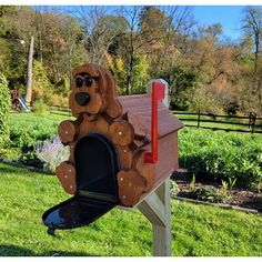 a wooden dog mailbox with sunglasses on it