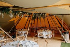 the inside of a tent with tables and chairs