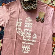 A Blush 100% Preshrunk Cotton T-Shirt In Unisex Sizing With Amazing Aztec Print Cactus On Front. Soft & Comfy Tee. If You Prefer More Is A Fitted Option I Would Recommend To Size Down. Smoke Free Home Boutique. Fast Shipper Western Style Pink Tops For Spring, Western Pink Tops For Spring, Pink Bohemian Tops With Crew Neck, Pink Western Tops For Spring, Pink Western Style Spring Tops, Bohemian Pink Tops With Graphic Print, Bohemian Pink Crew Neck Top, Pink Bohemian Crew Neck Top, Pink Short Sleeve Western Top