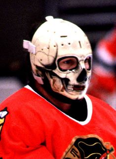 a hockey player wearing a white mask and red jersey