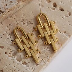 Modern Gold-tone Drop Linear Earrings, Trendy Gold-tone Dangle Earrings, Chic Gold Linear Metal Earrings, Elegant Geometric Gold Earrings, Elegant Gold Geometric Earrings, Modern Geometric Gold Earrings, Modern Gold Geometric Earrings, Trendy Gold Dangle Linear Earrings, Elegant Geometric Metal Hoop Earrings