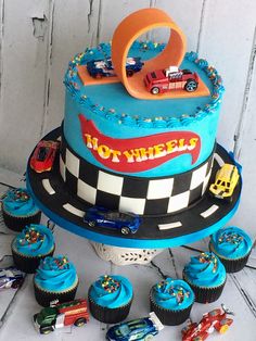 a birthday cake with cars on it and cupcakes