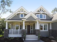 a gray house with white trim and two story front porches on the first floor