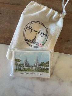 the bag is next to an envelope with a picture of a castle and trees on it