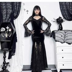 The wannathis Gothic Velvet Mermaid Gown is an elegant, floor-length dress featuring long sleeves, lace detailing, and a high collar. This gown combines the luxurious texture of velvet with intricate lace accents, creating a sophisticated and dramatic gothic look. Fabric composition: 95% Polyester, 5% Spandex (Elastane) Long Sleeve Dress With Lace Trim, Long Sleeve Lace Evening Dress With Sheer Sleeves, Evening Long Sleeve Maxi Dress With Lace Trim, Long Sleeve Maxi Dress With Lace Trim For Evening, Fitted Long Gothic Dress, Stretch Long Sleeve Maxi Dress For Prom, Black Lace Trim Floor-length Gown, Black Floor-length Gown With Lace Trim, Gothic Long Sleeve Dress For Night Out