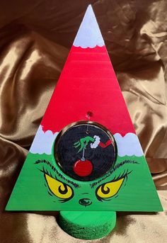 a wooden christmas tree with an elf's face painted on the front and bottom