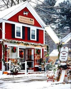 a red building covered in snow with christmas decorations on the front and side of it