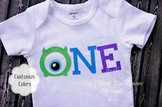 a white onesie with the word one printed on it and an eyeball at the center