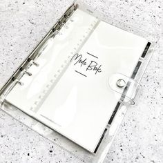 a clear binder with a note book and pen on the bottom that says mr ble