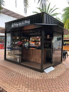 the outside of a small bar with palm trees in the background