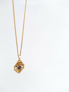 "14k solid yellow gold boho-chic pendant necklace set with a sapphire. This dainty necklace is made of 14k yellow gold and has a diamond-shaped solid gold pendant. The pendant has an elaborate ethnic-boho design and is set with a shiny blue sapphire. This 14k solid gold necklace is beautiful and chic and will upgrade any outfit you'll wear. It is perfect for everyday use but will also stand out in any high-class occasion. You can wear it as a single item or layered with other necklaces for a tot Gold Sapphire Jewelry Gift, Gold Sapphire Jewelry For Gift, 14k Gold Square Pendant Necklace With Birthstone, Handmade Yellow Gold Sapphire Jewelry, Handmade Yellow Gold Necklace With Square Pendant, Gold Sapphire Necklaces For Gift, Gold Sapphire Necklace For Gifting, Gold Sapphire Necklace For Gift, Delicate Yellow Gold Necklace With Square Pendant