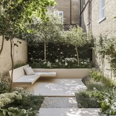 an outdoor seating area with benches and trees in the back ground, surrounded by shrubbery