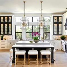 a large kitchen with white cabinets and black counter tops, along with an island in the middle