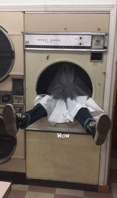 a person laying on top of a washing machine