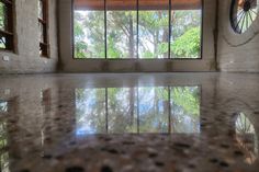 an empty room with large windows and tiled floor