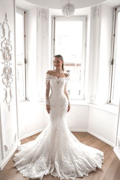 a woman in a white wedding dress posing for the camera with her hands on her hips