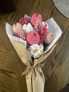 a bouquet of crocheted hearts wrapped in brown paper