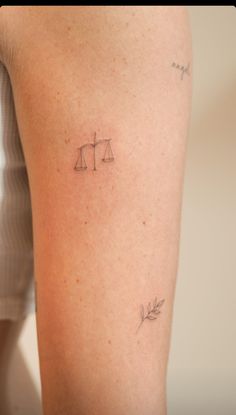 a woman with a tattoo on her leg that has a scale and leaves on it