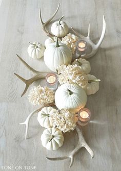 a table topped with white pumpkins and flowers