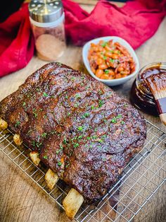 a large piece of meat sitting on top of a metal rack next to other foods