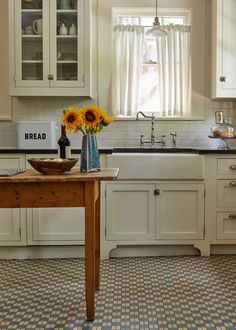 a kitchen with sunflowers in a vase on the counter