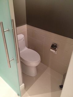 a white toilet sitting in a bathroom next to a green door