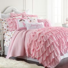 a bed with pink ruffled sheets and pillows